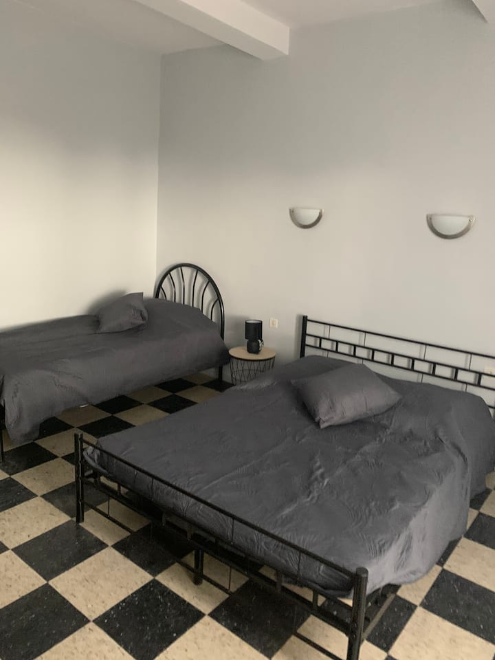 卧室配有一张双人床和一张单人床，还有一个阳台