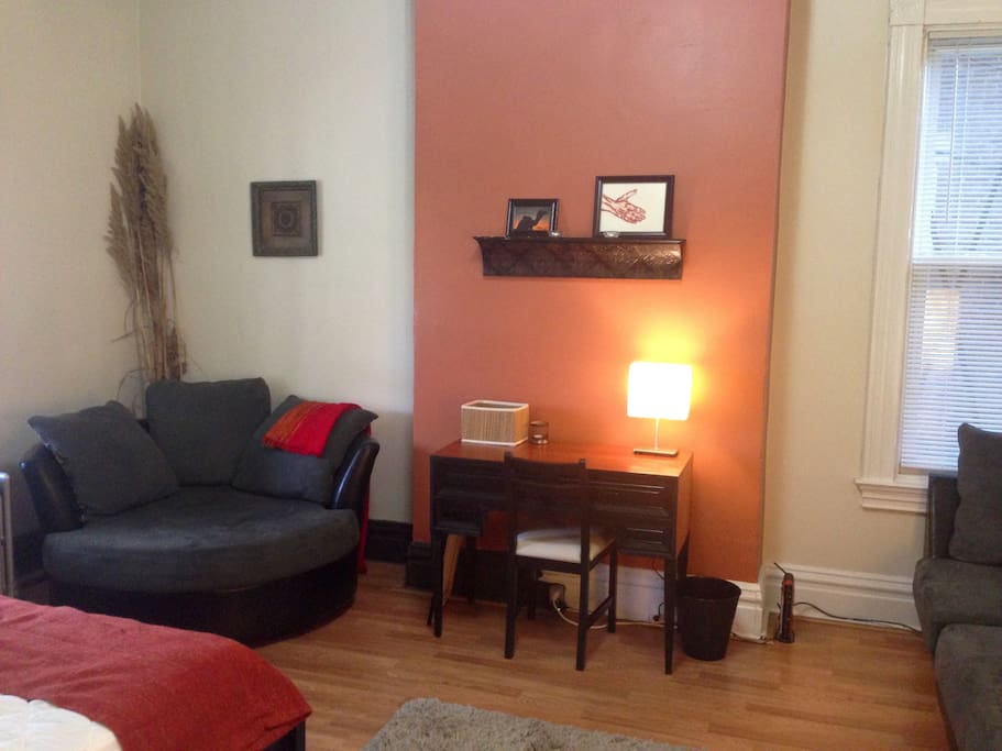 Bedroom work desk, large cushy chair, and couch