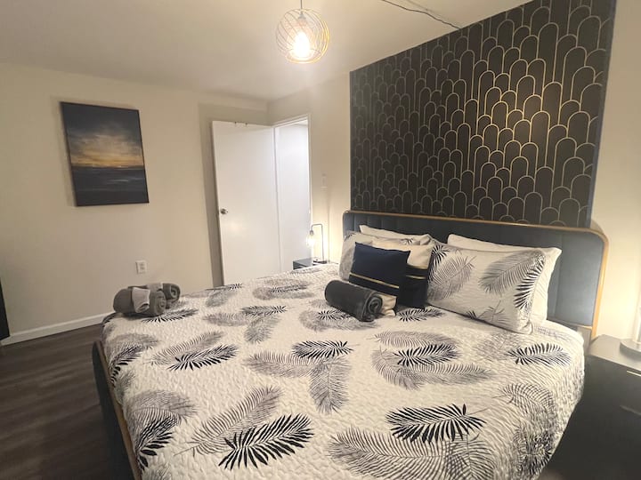 First Bedroom featuring King Sized Bed, Smart TV, and En Suite Attached Full Bathroom w/ Tub