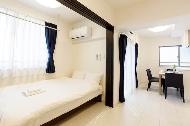 A semi-double bed is set near the window. The area can be partitioned into a private bedroom with the sliding door.