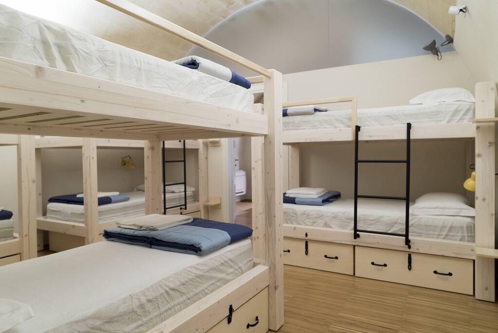 Camera da letto con 4 letti a castello in legno con cassettiera