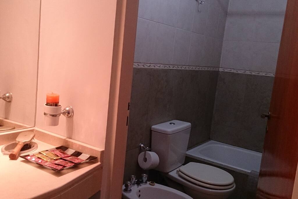 Baño con bañera y ducha. Elementos de higiene personal: gel de ducha, shampú, acondicionador, shampú para manos.