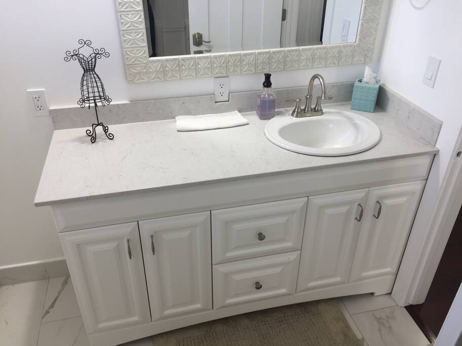Quartz bath countertop/spash, new cabinet, and new porcelain tile.