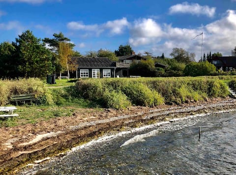 Idyllic black cottage first row to the sea