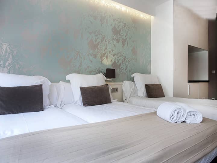 3 sigle beds in a open space with a small kitchenette