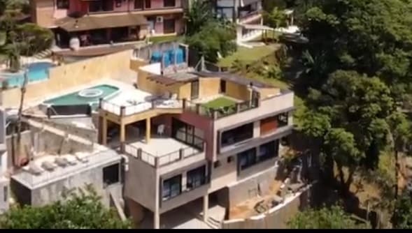 A view of a multi-level property featuring spacious balconies and an integrated pool area. Surrounding green trees provide a natural backdrop, while the terrace offers open space for relaxation. The layout ensures a connection between indoor and outdoor living spaces.