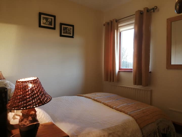 第三间卧室配有双人床，可俯瞰开放式乡村风光 