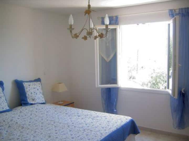 This room, decorated in blue, is the house's master bedroom. The bed is 180 cm wide. In the room, there is a closet, 2 wicker chairs, and a small table. From the room, there is a beautiful view of the mountains, the Vallée de la Durance, and the house's olive trees.