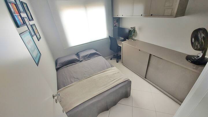 غرفة بسرير مزدوج ومكتب وشاشة 30بوصة مع كابل HDMI ومروحة. الحمام أمام باب غرفة النوم. 