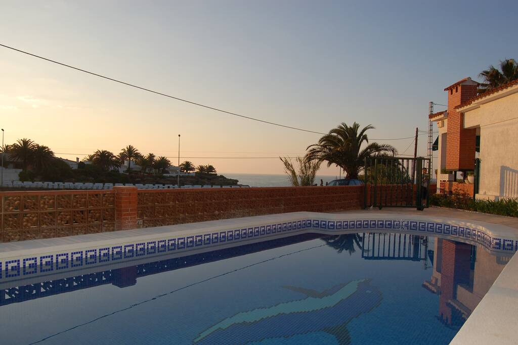 Zone piscine protégée par un portail avec la vue sur la mer