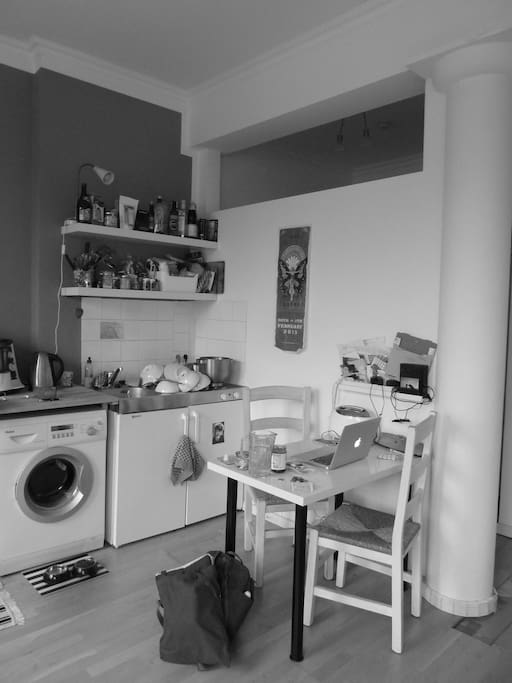 Die Kochecke mit Esstisch, Kühlschrank und Waschmaschine