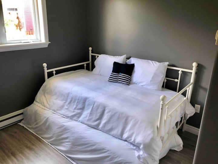 Kitanda pacha kilicho na kitanda kingine pacha chini ambacho kinatoka nje. 