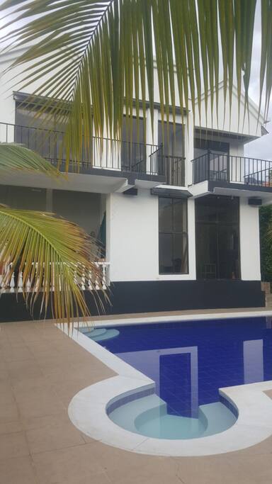 Entrada a la casa de dos niveles y amplios ventanales