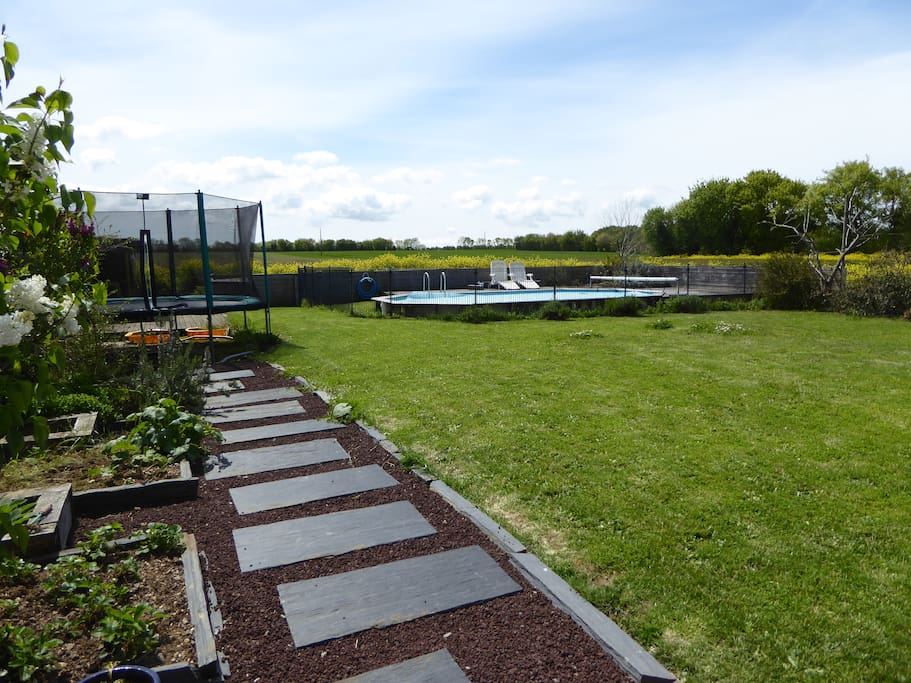 Un joli terrain avec trampoline, barbecue, piscine...