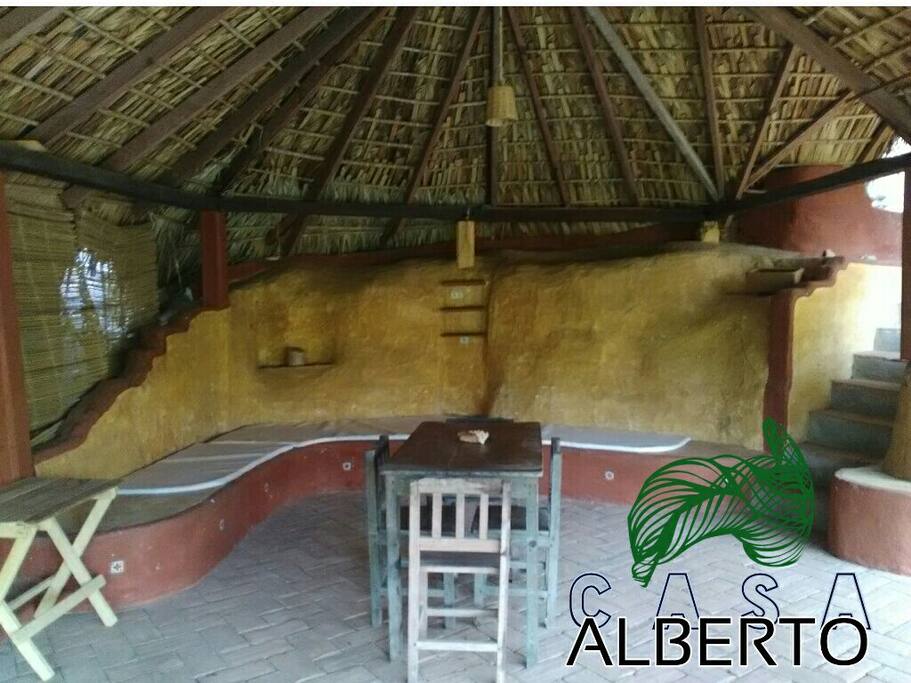 Terraza exterior con mesa para comer y banco de obra con colchoneta.