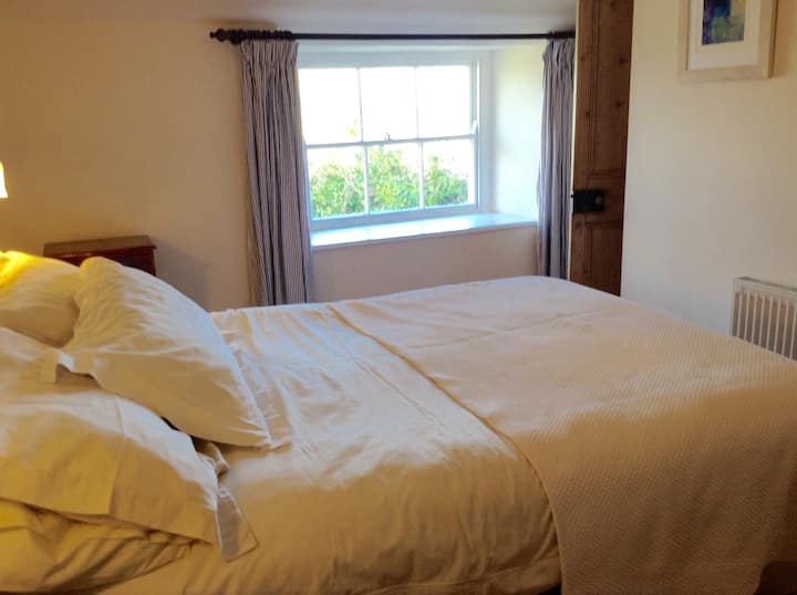 Dormitorio con vista lejana al mar desde el asiento de la ventana