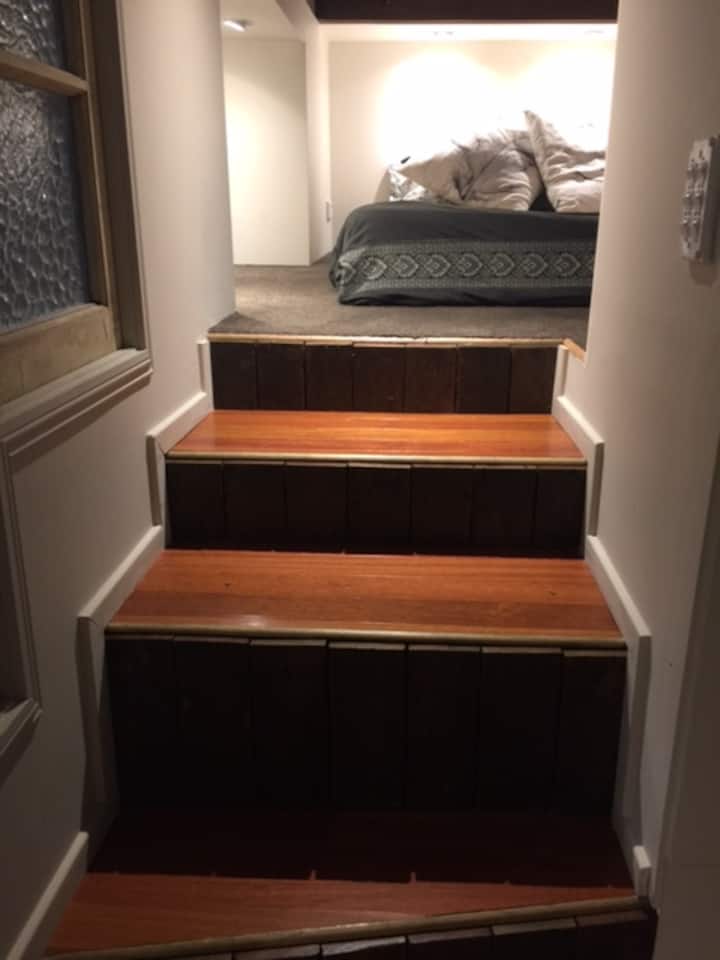 Ngazi ndogo zinaelekea kwenye kitanda cha watu wawili cha mtindo wa Bunker.