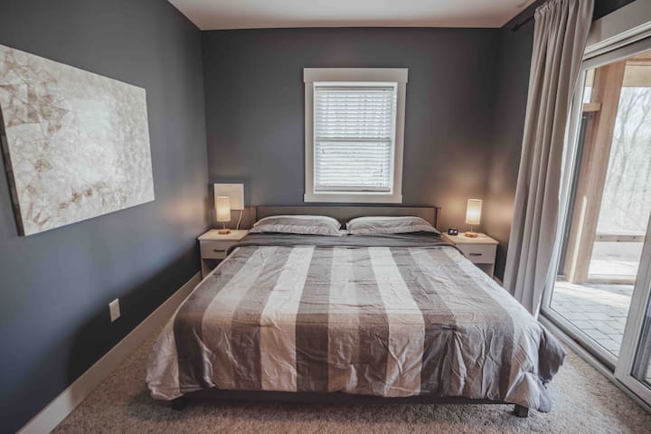 1 of 2 identical bedrooms on the lower level with super cozy King bed, satellite TV and quick walk out access to the large screened in patio.