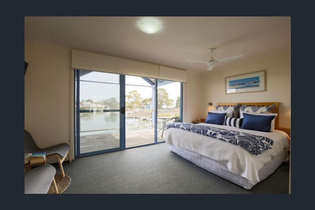 King bed upstairs with balcony overlooking the water.