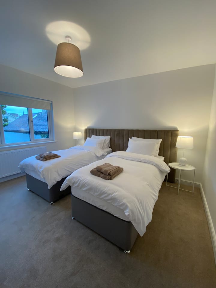 Chumba cha kulala cha 2: Ghorofa ya chini. Inaweza kuwekwa kama mapacha /superking. Luxury sateen bedlinen, uchaguzi wa mito manyoya/ synthetic na kipofu blackout ili kuhakikisha usingizi mzuri wa usiku! Samani za kujumuisha meza za kando ya kitanda, droo, nguo zilizoning 'inia na kioo.