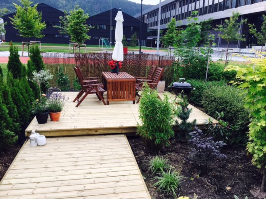 The sunny garden with barbeque . No traffic at the outside.