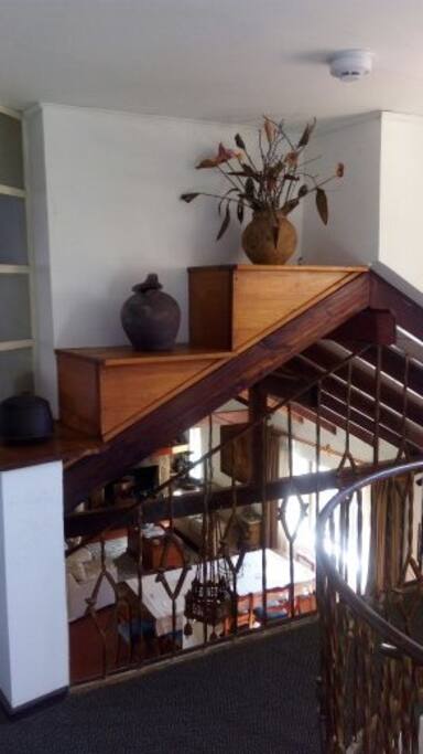 Hall al subir escala de caracol, con vista a la entrada y living comedor de la casa.