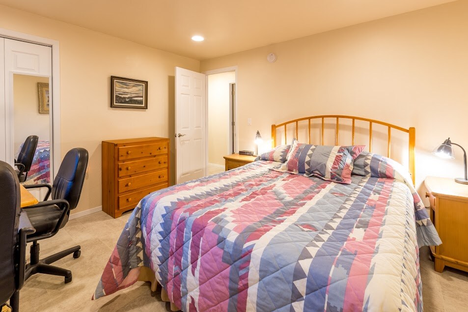 ห้องพักที่สดใสนี้อยู่ตรงข้ามห้องโถงจากห้องน้ำและมีเตียงควีนไซส์