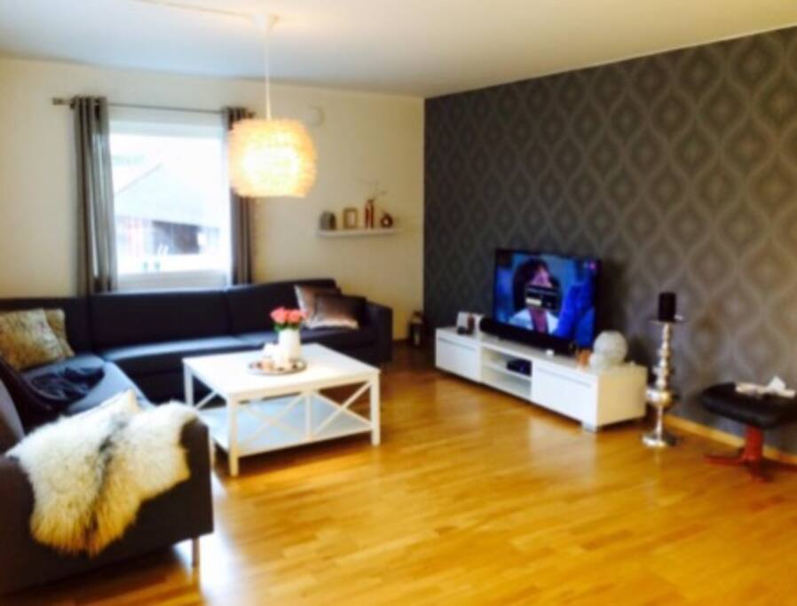 Rommeleg stue med stor vinkelsofa. Flatskjerm og breiband