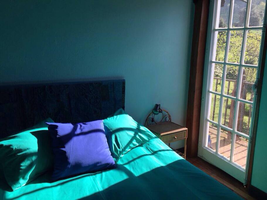 Cama y acceso al balcón de la fachada principal.