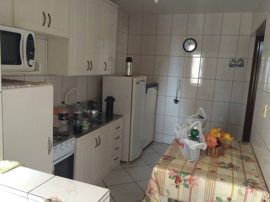 Cozinha completa com utensílios, microondas, fogão, geladeira, freezer.