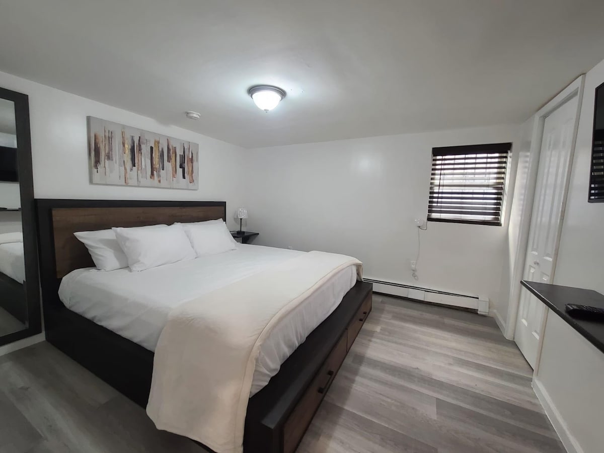 Chambre King équipée d'un miroir pleine longueur et d'une télévision connectée.