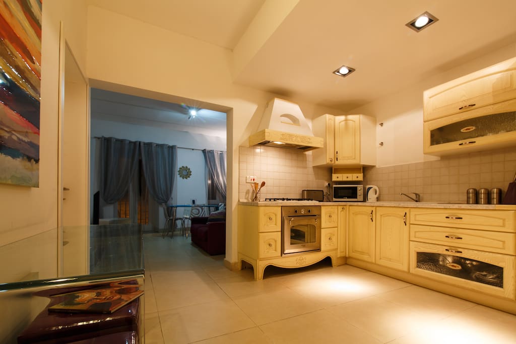 Kitchen with 4 gas hobs, electric oven, microwave & washing machine.