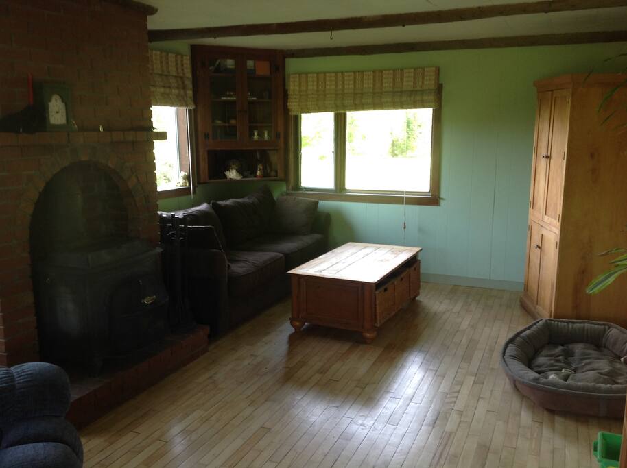 Living room with wood stove and television in the cabinet.