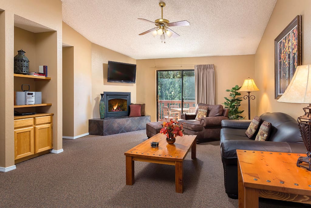 Relax in the living room with cozy couches, a fireplace, and a flat-screen TV