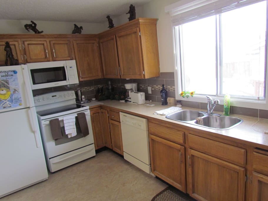 Very nice kitchen with all the pots and pans and dishes and utensils.