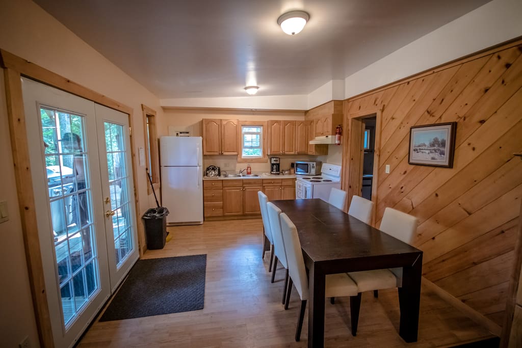 The entrance/kitchen: The chalet includes a fully equipped kitchen and dining area. The covered porch with BBQ and seating can be seen to the left in this photo.