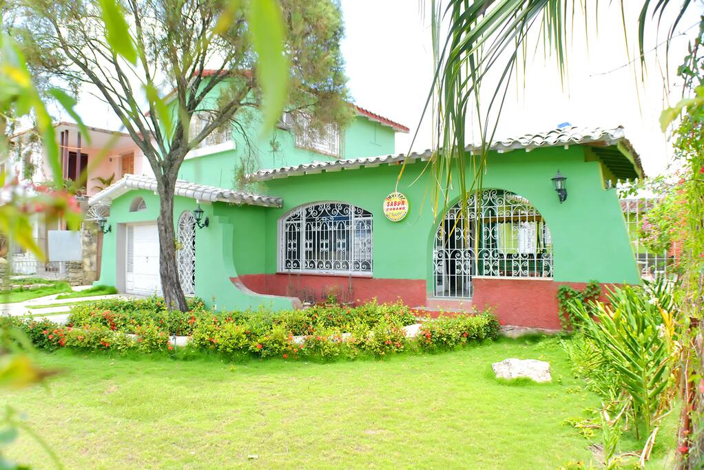 Frente de la casa con el jadín.