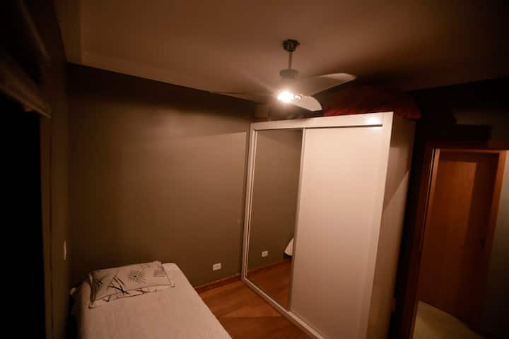 Single room with lockers and wooden bed with common mattress. 