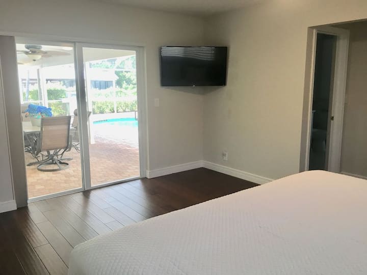 غرفة نوم بسرير كينج فوق باب منزلق خاص بمسبح 