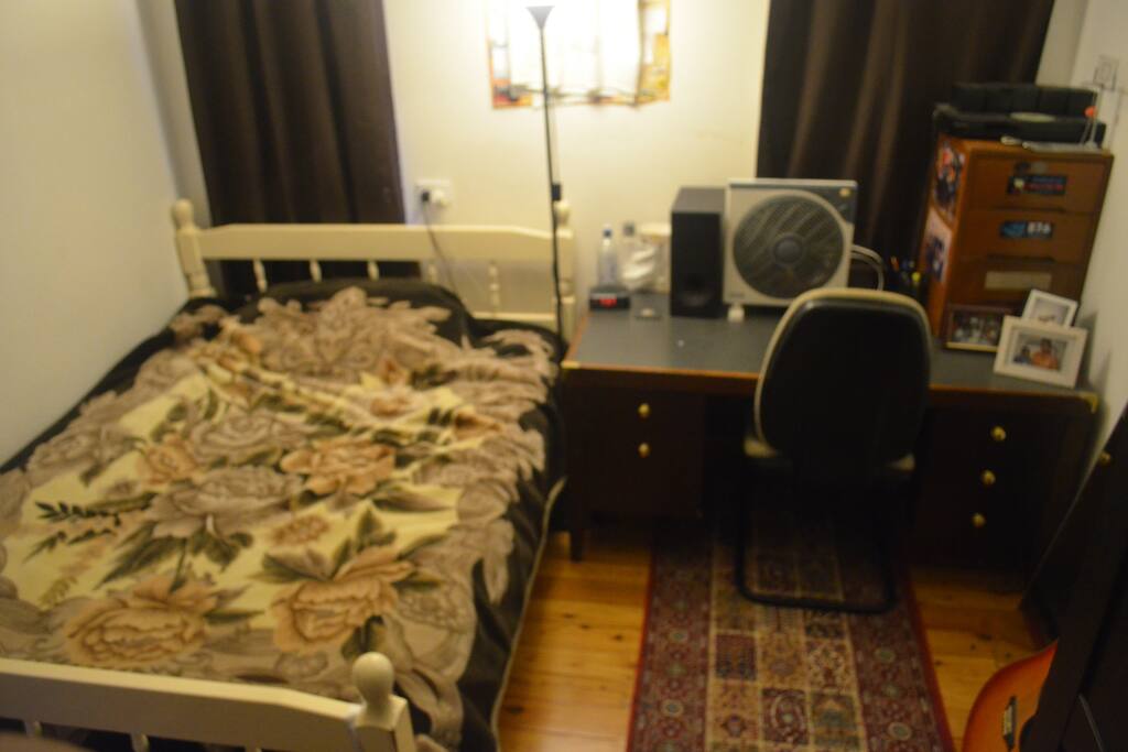 Bedroom with desk, fan and chair