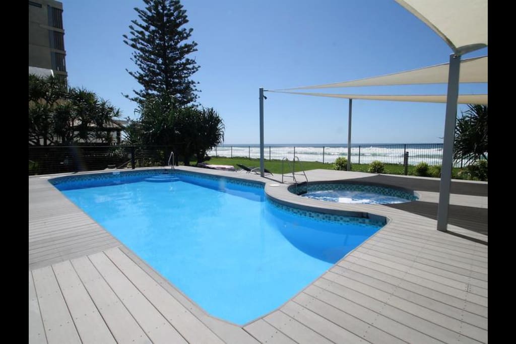 Pool and spa area with lawn leading directly to private beach access