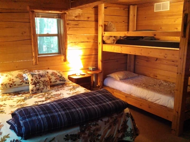 Поголема спална соба со брачен кревет и кревети.