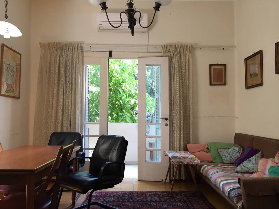 Lounge with table, sofa and double doors to balcony
