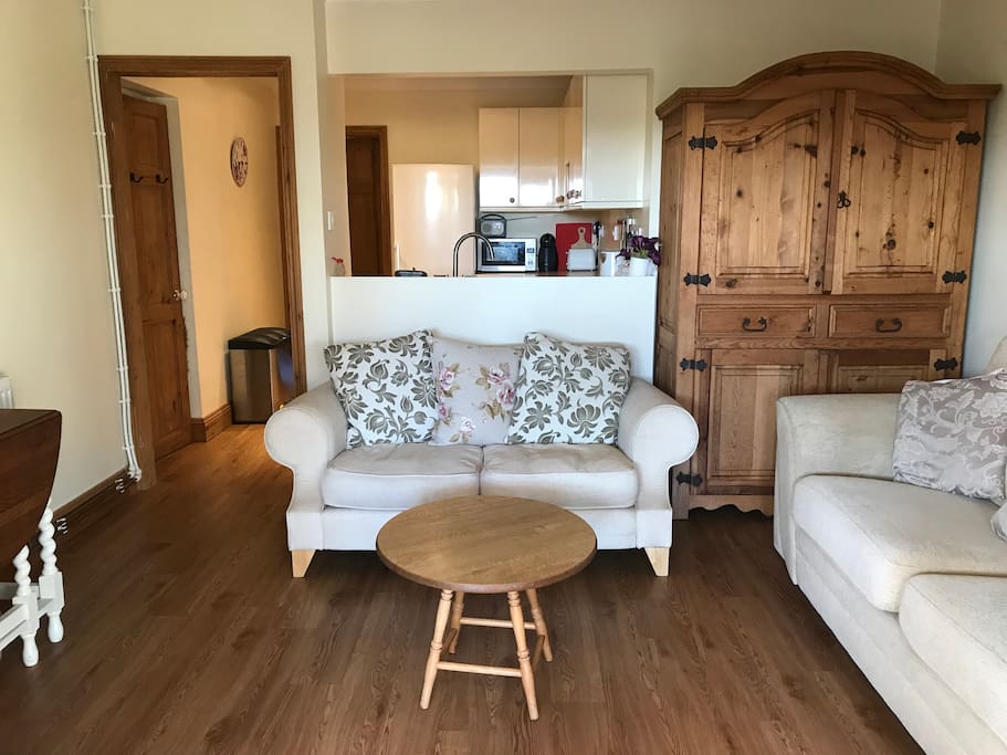 This is the lounge. There are two sofas, a tv, a dining table and 2 chairs.