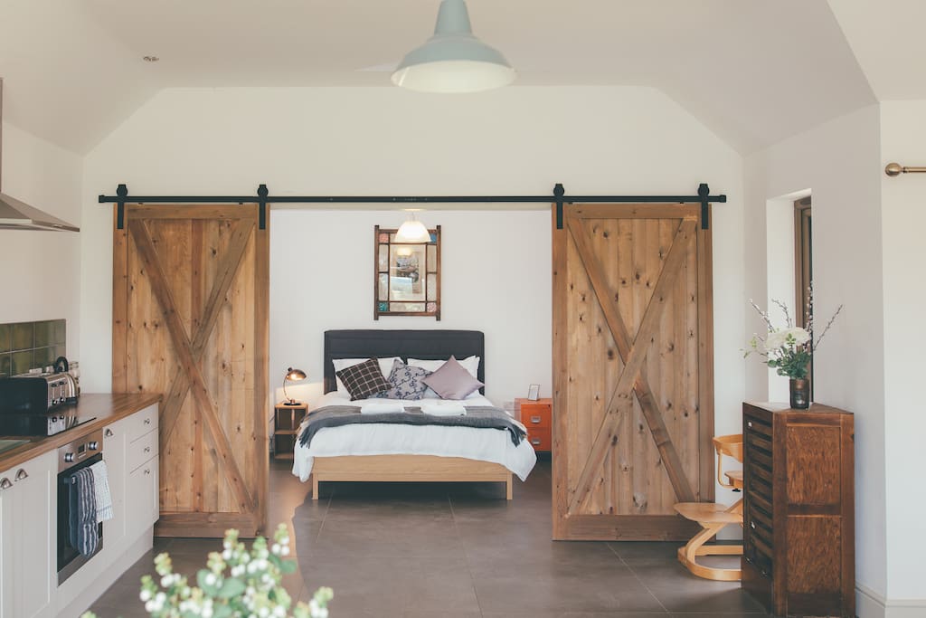 Beautiful barn doors frame the master bedroom in Alice Barn