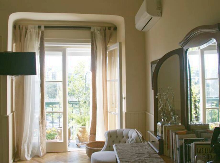 Dormitorio luminoso con balcón y vista al parque.