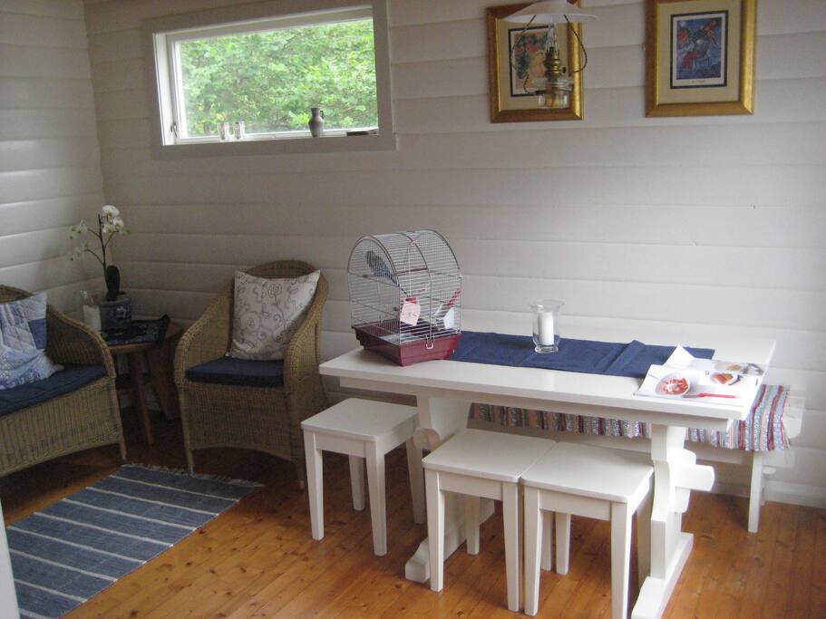 The living room has a sofa and three chairs, fireplace and a dinner table.