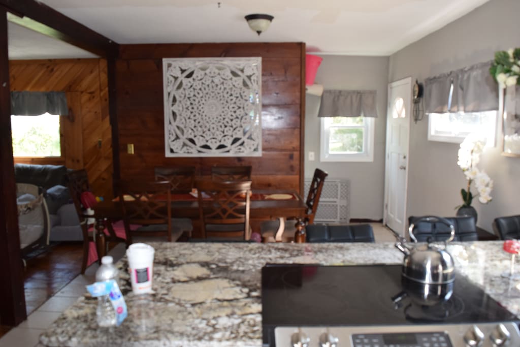 6 person dining table with 3 bar stools at end of granite.
