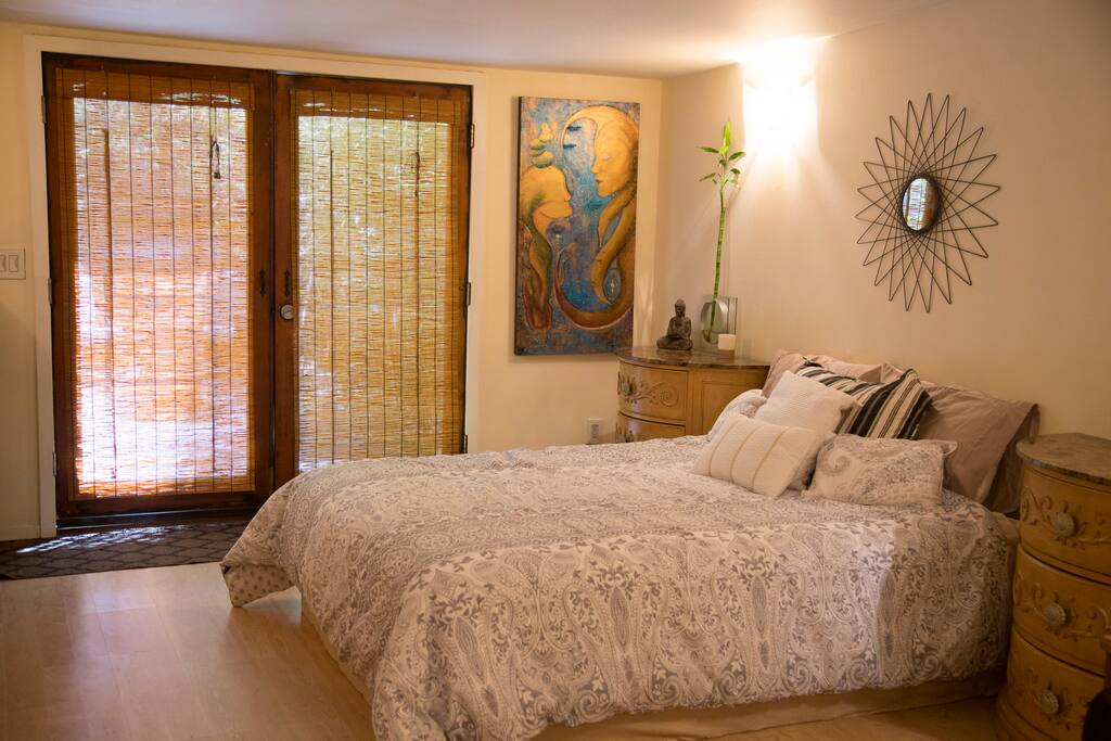 "Main living space with bamboo blinds and one-of-a-king original artwork from our collection"