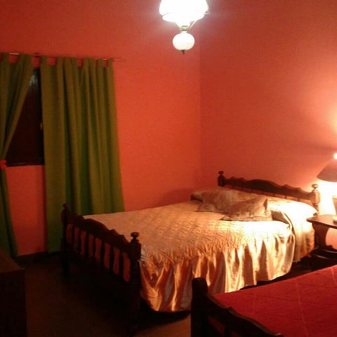 Habitación amoblada con escritorio, perchero y mesa de luz.